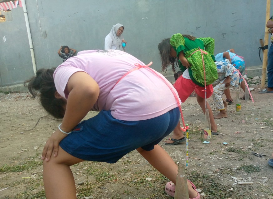 Anak -anak Kampung karang ayu mengikuti lomba memasukan pulpen ke dalam botol minuman kosong