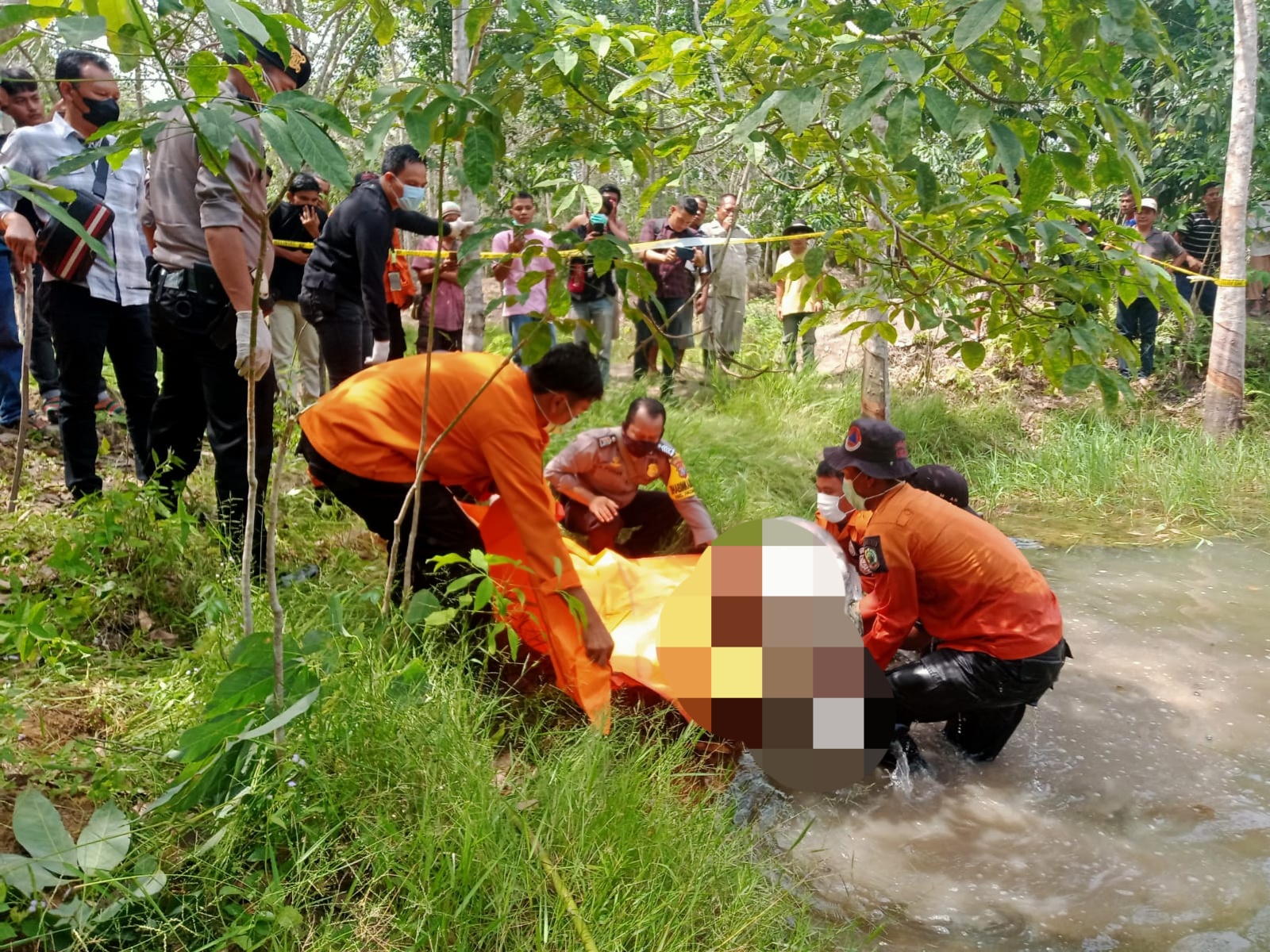 Di saksikan masyarakat, personel Polsek Padang Bolak dan Tim gabungan melakukan proses evakuasi usai temukan sesosok mayat Mr X dalam keadaan tanpa busana yang terapung di Kolam galian Perkebunan Karet di Simpang Barumun, Desa Sipaho, Kecamatan Halongonan, Kabupaten Paluta