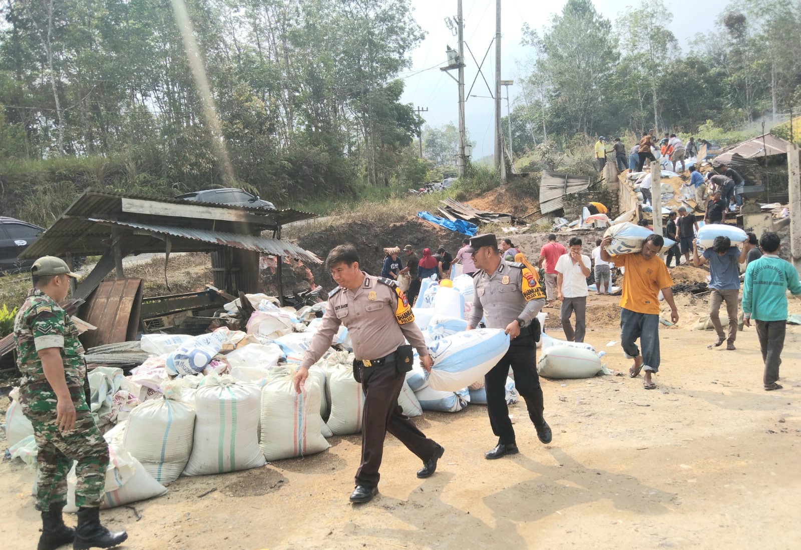 Sejumlah personel Polsek SD Hole saat berupaya membantu menyelamatkan barang-barang berharga di Kilang Padi di Desa Sautbanua Simanosor, Kabupaten Tapsel, yang ludes terbakar api