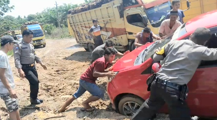 Potret Polri penolong saat membantu mobil warga yang terpuruk ke luar dari jebakan lumpur di Desa Hiteurat, Kecamatan Halongonan, Kabupaten Paluta