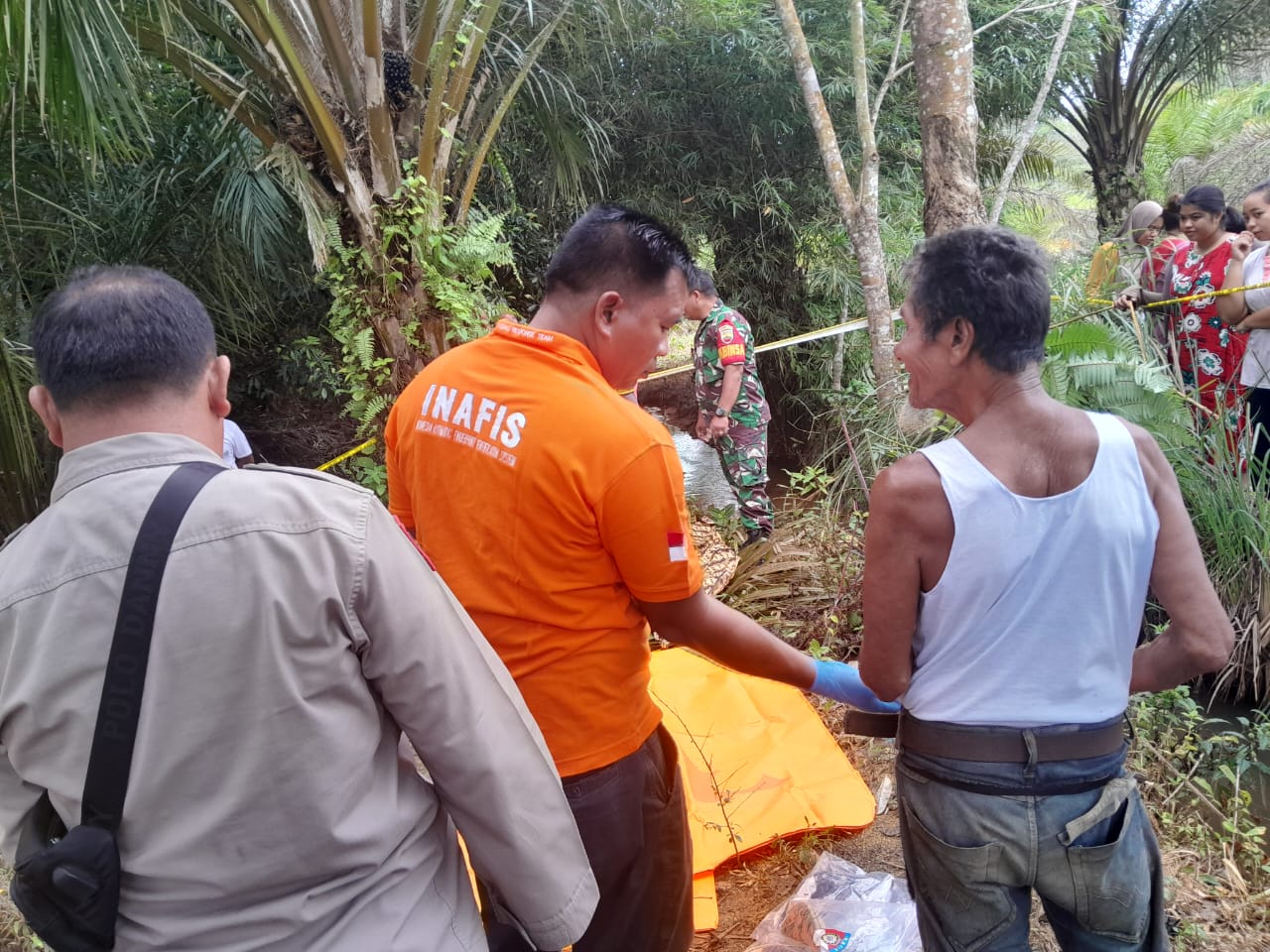 Polisi saat menggelar olah TKP atas temuan sosok jasad pria yang tergantung di Pohon Karet