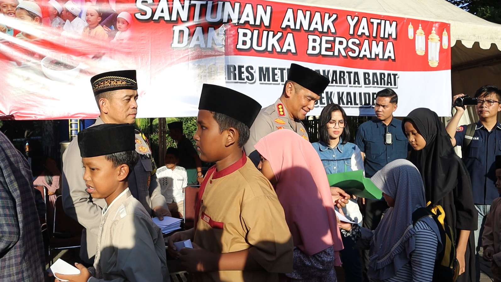 Kapolres Jakarta Barat, Kombes Pol M Syahduddi bersama Kapolsek Kalideres saat membagikan santunan anak yatim