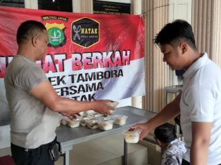 Jajaran Polsek Tambora Jakarta Barat saat membagikan nasi kotak pada jemaah masjid Bahrul Huda