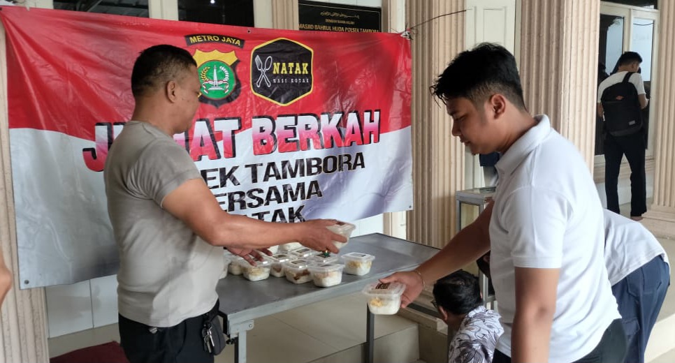 Jajaran Polsek Tambora Jakarta Barat saat membagikan nasi kotak pada jemaah masjid Bahrul Huda