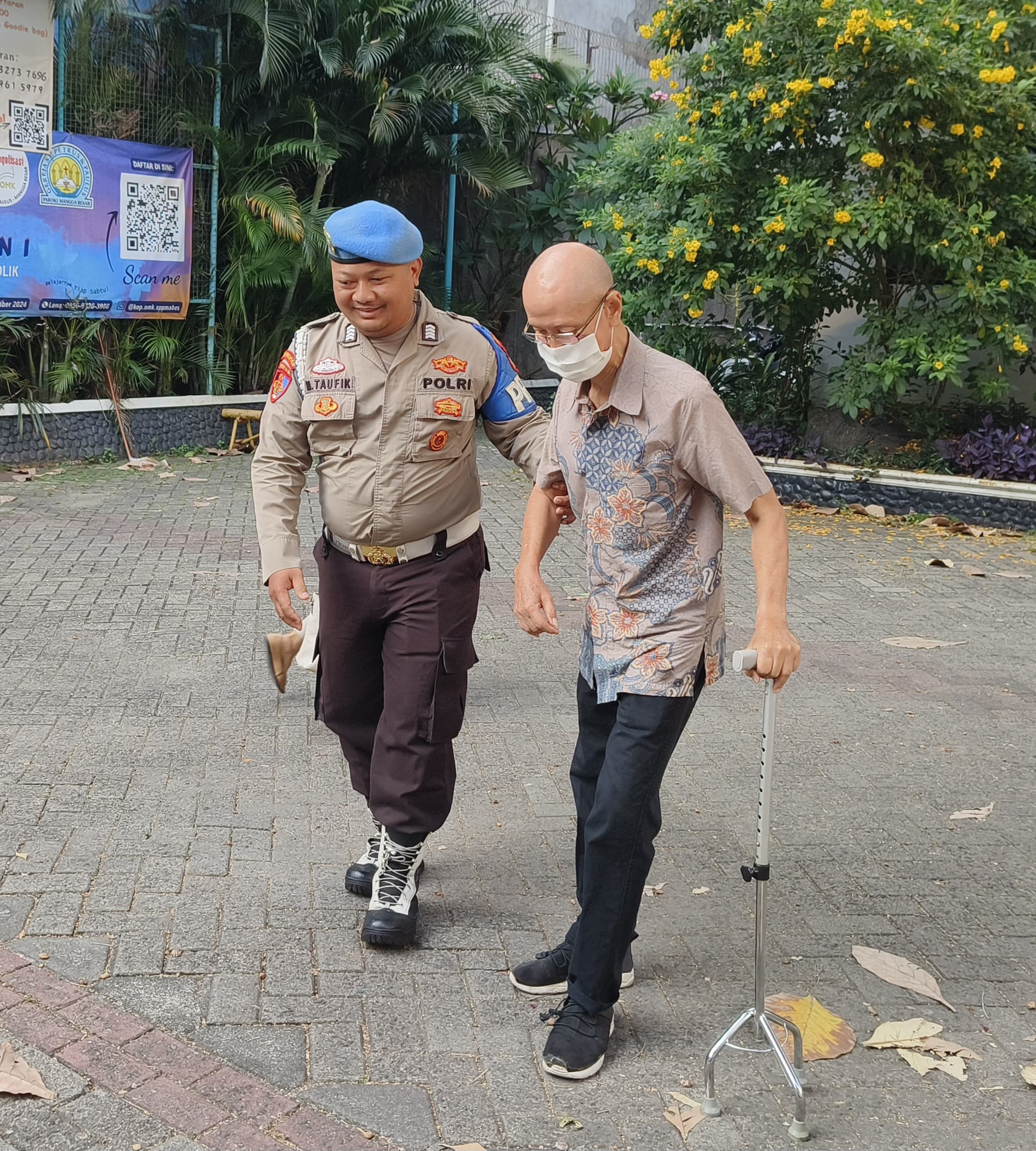 Bripka M. Taufik, yang terlihat dengan penuh perhatian dan kelembutan menggandeng seorang umat yang berusia lanjut untuk memasuki gereja.