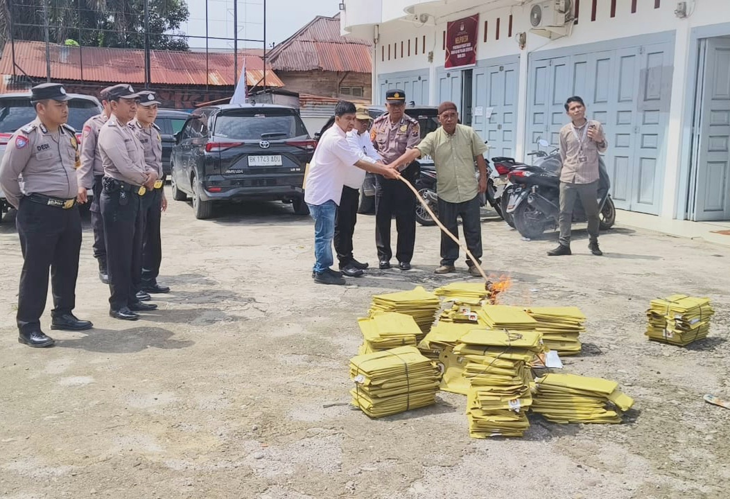 Kapolsek Padang Bolak, AKP Harun Manurung, bersama Ketua KPU Paluta, Raja Dolok Harahap, saat pemusnahan soal tertulis calon PPS pemilihan Gubernur dan Wakil Gubernur, serta Bupati dan Wakil Bupati