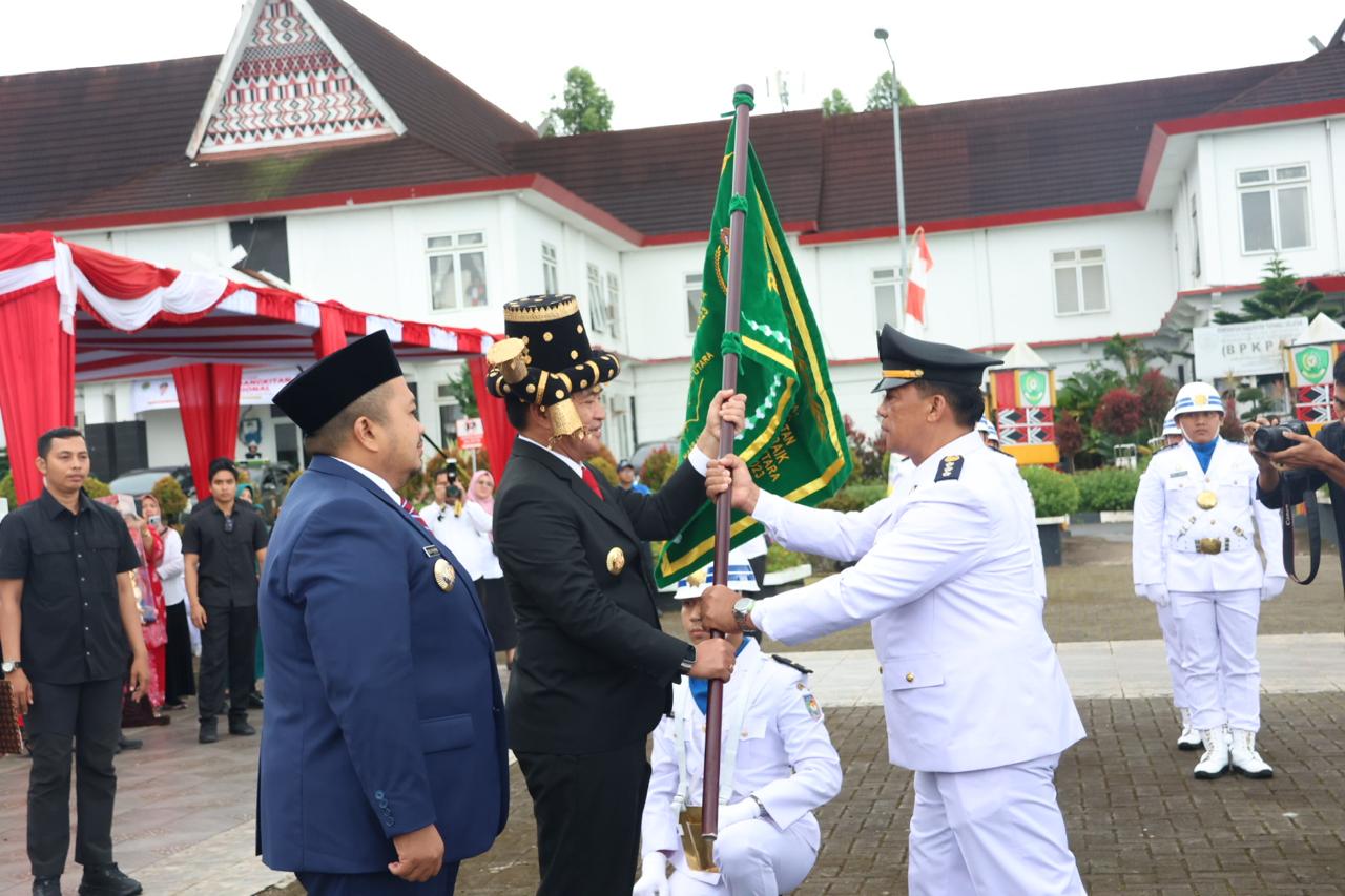 Pj Gubsu, Hasanuddin, didampingi Bupati Tapsel, Dolly Pasaribu, menyerahkan Tunggul Kecamata terbaik pertama tingkat Provinsi Sumut kategori Kabupaten tahun 2023 kepada Camat Sipirok, Sahruddin Perwira