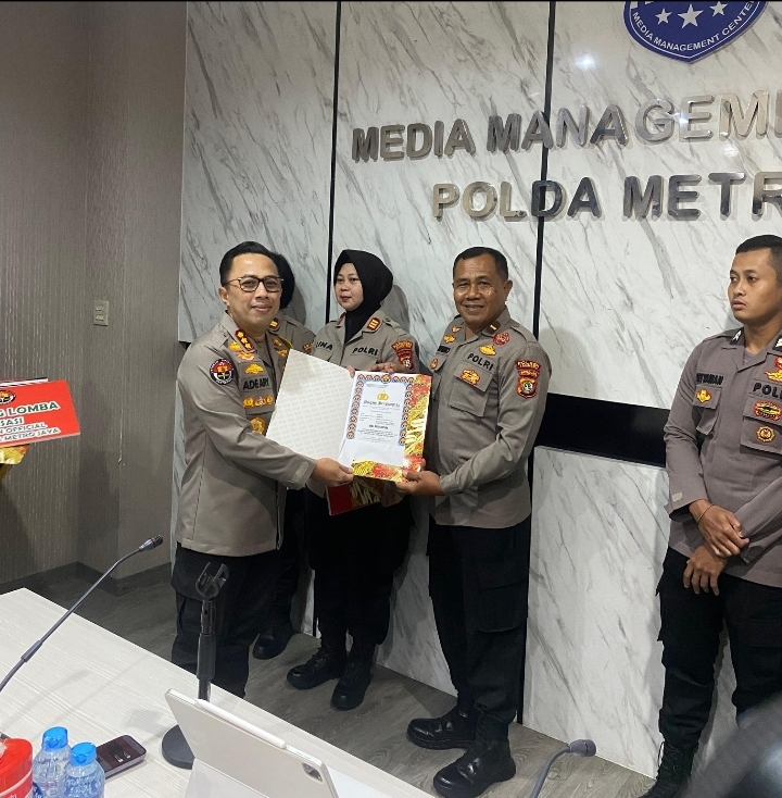 Kabid Humas Polda Metro Jaya Kombes Pol. Ade Ary memberikan penghargaan kepada Kasi Humas Polsek Tambora Polres Metro Jakarta Barat.