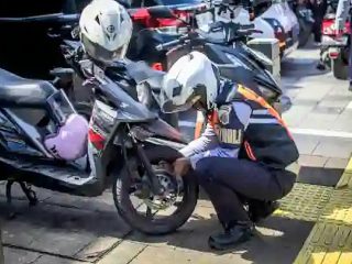 Petugas saat melakukan sanksi Cabut Pentil kepada Sepeda Motor yang Parkir Sembarangan dikawasan Jakarta Selatan