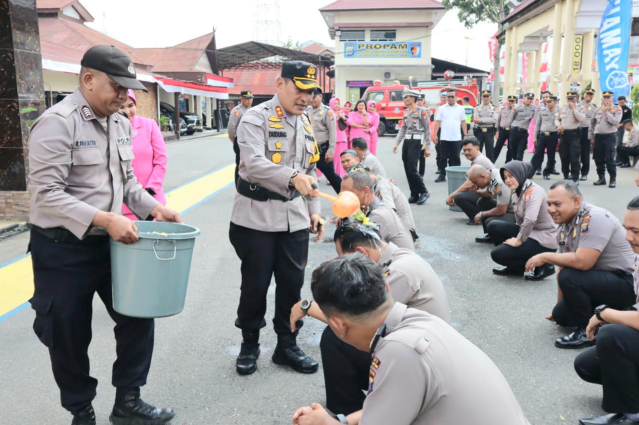 Kapolres Padangsidimpuan, AKBP Dudung Setyawan, menyirami air bungka ke personel yang naik pangkat