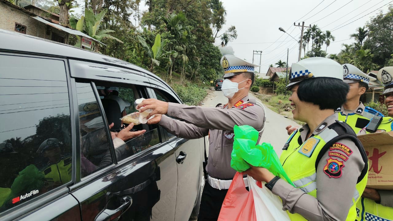 Kasat Lantas Polres Tapsel, AKP Danil Saragih, saat tengah menunjukkan aksi humanis dengan menyapa dan bagikan ratusan nasi kotak ke pengendara yang terjebak macet di jalan ekstrem Batu Jomba, Desa Luat Lombang, Kecamatan Sipirok