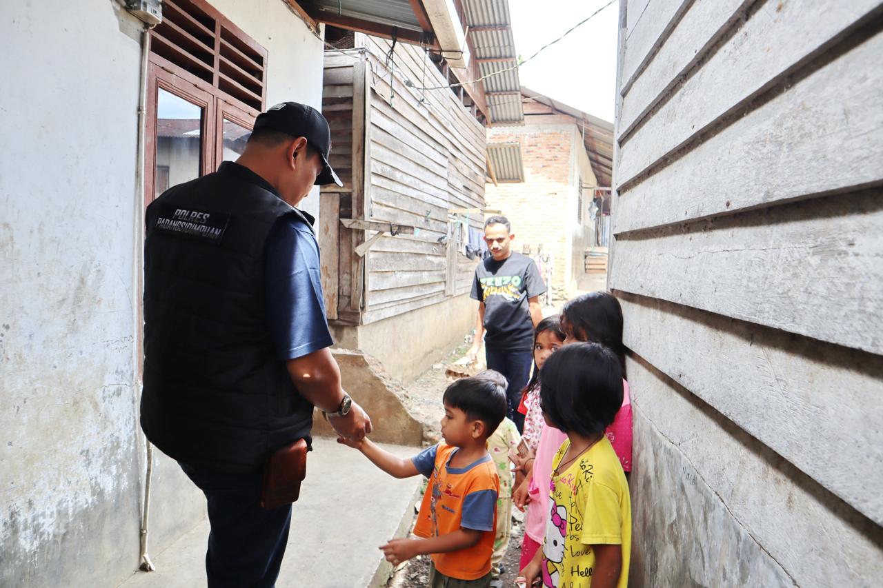 Kapolres Padangsidimpuan, AKBP Dudung Setyawan, dikerubungi anak-anak seraya memberikan uang jajan usai ia menyambangi sejumlah kediaman warga Pra Sejahtera guna memberi bantuan sosial