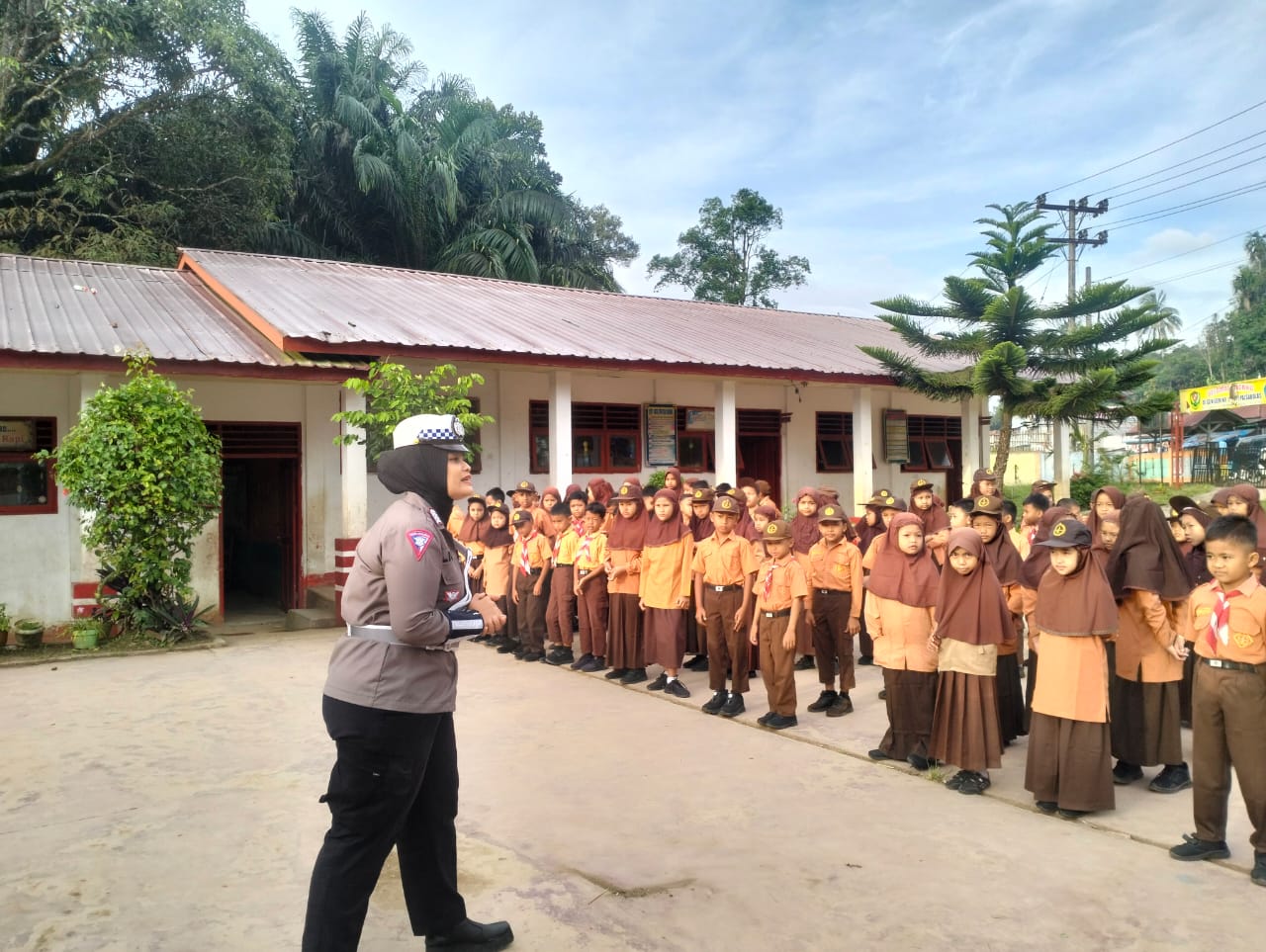 Personel Sat Lantas Polres Tapsel, Bripka Amalisa Siregar, saat memberi himbauan ke siswa SD di Desa Sidadi agar tidak bermain sepeda di jalan raya dalam rangka Operasi Patuh Toba 2024