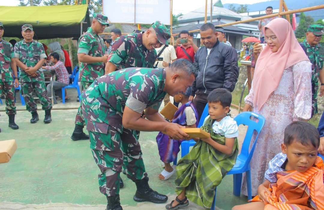 Danrem 023/KS, Kolonel Inf Lukman Hakim, didampingi Dandim 0212/TS, Letkol Inf Amrizal Nasution, saat menyerahkan bantuan berupa peralatan Sekolah ke anak-anak yang mengikuti kegiatan khitanan massal