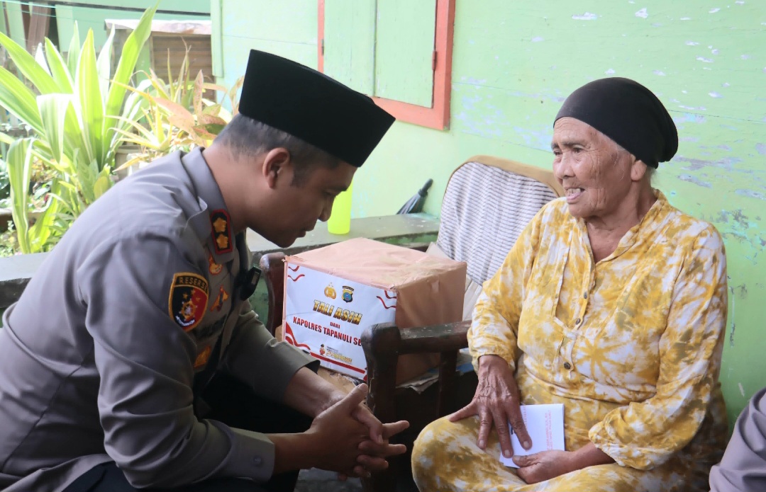 Kapolres Tapsel, AKBP Yasir Ahmadi, memberi bantuan sosial ke salah satu warga Pra Sejahtera sebelum membagikan ratusan nasi kotak dalam rangka program rutin Jumat Berkah