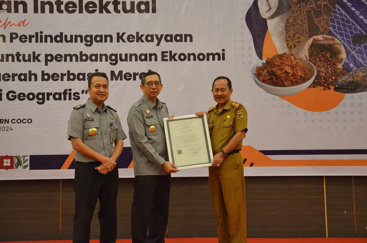 Kepala Kantor Wilayah Kemenkumham Sulteng, Hermansyah Siregar menyerahkan sertifikat KI Komunal Tombak Doke.