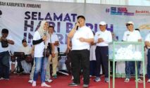 Bupati Jombang Warsubi (tengah) tersenyum saat mendampingi pemenang hadiah umroh dalam momen pengundian doorprize May Day di Stadion Jombang,